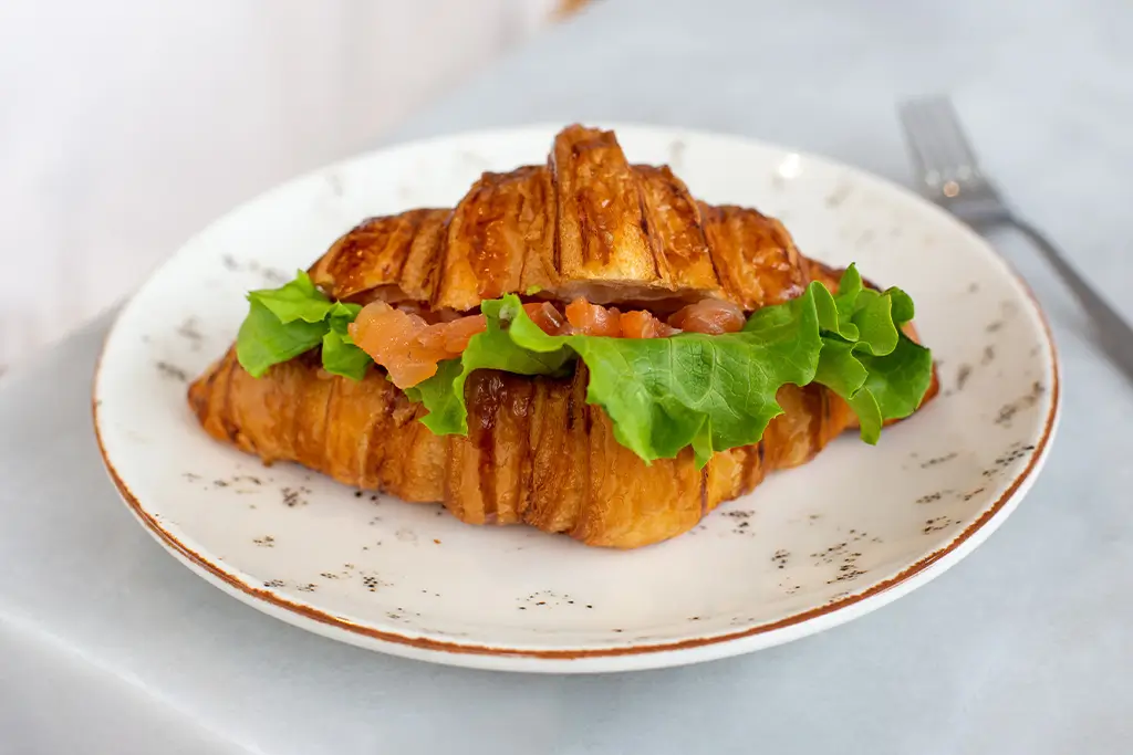 tasty-croissant-with-salad-and-salmon-on-white-pla-2025-02-22-01-44-17-utc